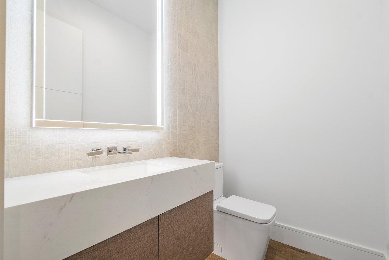 320 Northeast Wavecrest Way Boca Raton, FL 33432 - Photo 12 of 48 a bathroom with a sink a toilet and a mirror