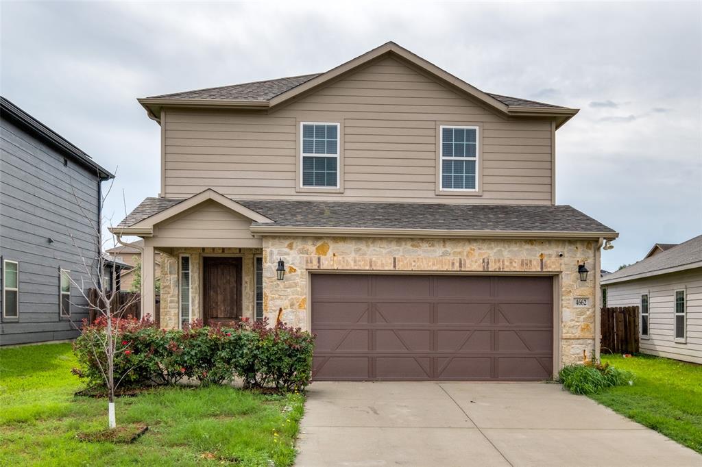 4662 Ralph Lane Dallas, TX 75227 - Photo 2 of 25 Two-story exterior with stone and siding facade, covered entry, attached garage with panel door, and concrete driveway