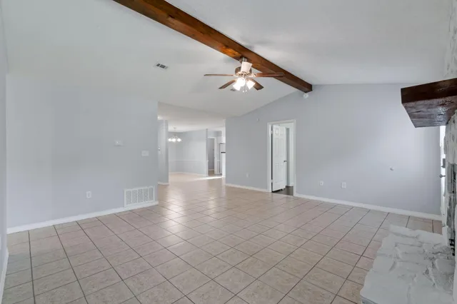 an empty room with windows and fireplace