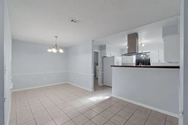 a view of a livingroom with a chandelier fan and windows