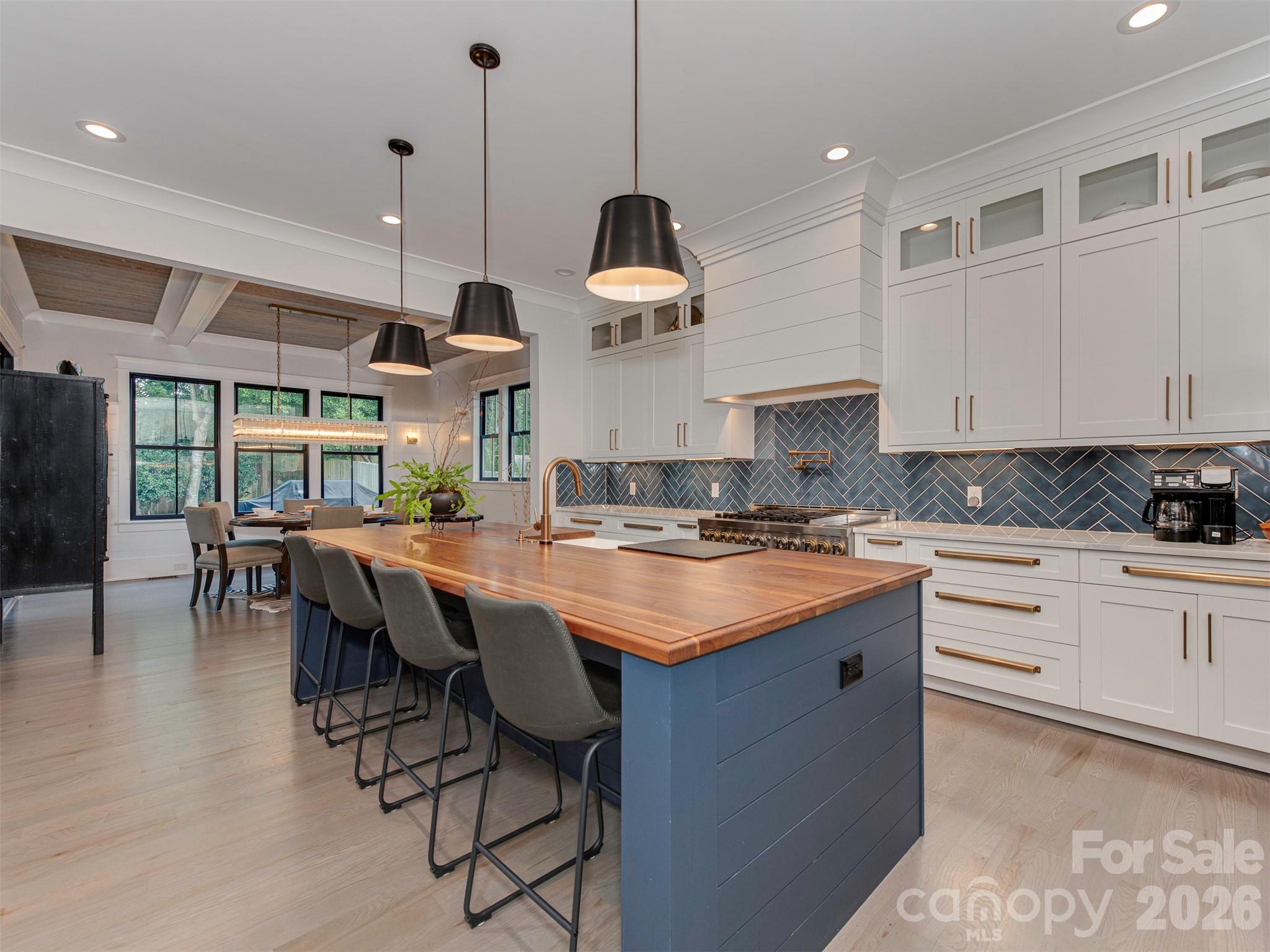 4009 Ridgecrest Avenue Charlotte, NC 28211 - Photo 11 of 43 a kitchen with a dining table chairs sink and cabinets