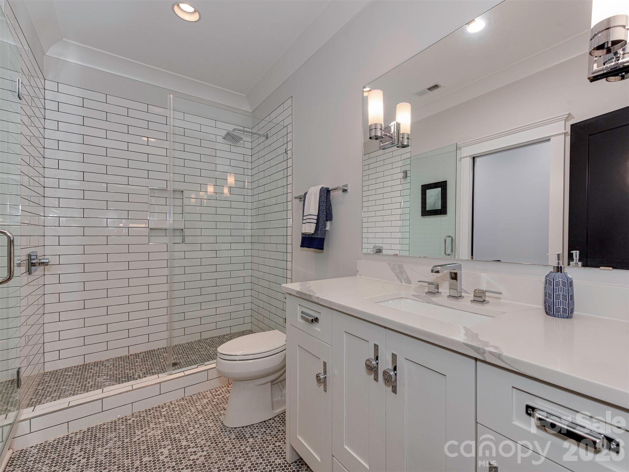 4009 Ridgecrest Avenue Charlotte, NC 28211 - Photo 28 of 43 a bathroom with a sink a toilet and mirror