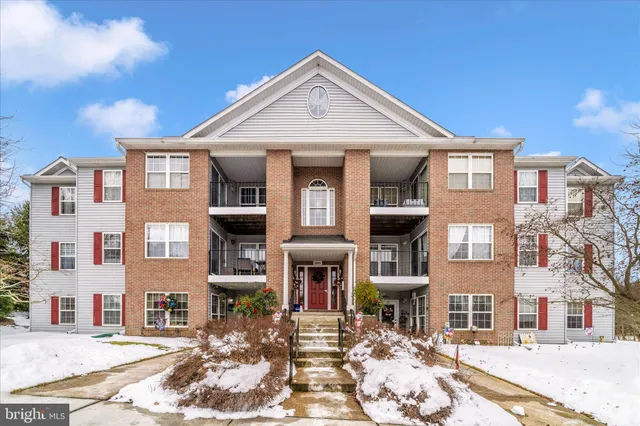 a front view of a residential apartment building with a yard
