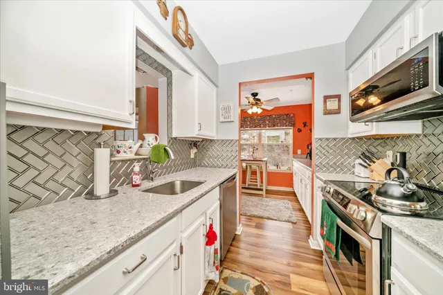 a kitchen with stainless steel appliances granite countertop a sink stove and cabinets