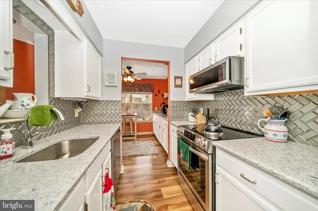 a kitchen with stainless steel appliances granite countertop a sink and a stove