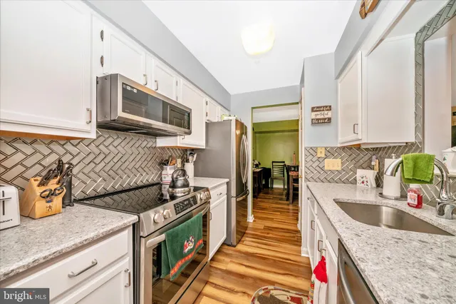 a kitchen with stainless steel appliances granite countertop a sink and a stove