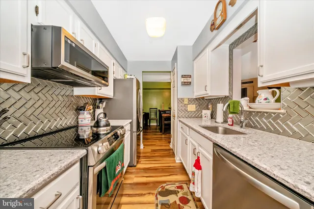 a kitchen with stainless steel appliances granite countertop a sink and a stove