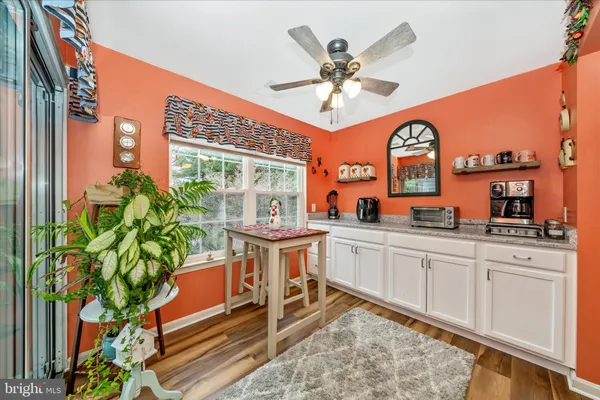 a very nice looking kitchen with granite countertop a stove a sink and a potted plant