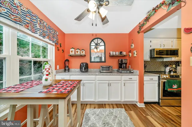 a kitchen with a sink a kitchen island a stove and a chandelier