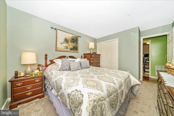 a bedroom with a bed and a lamp on dresser