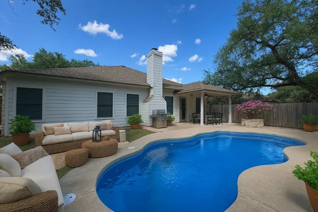 a view of a house with swimming pool and furniture