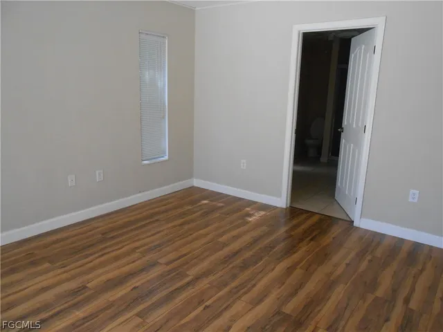 an empty room with wooden floor and closet