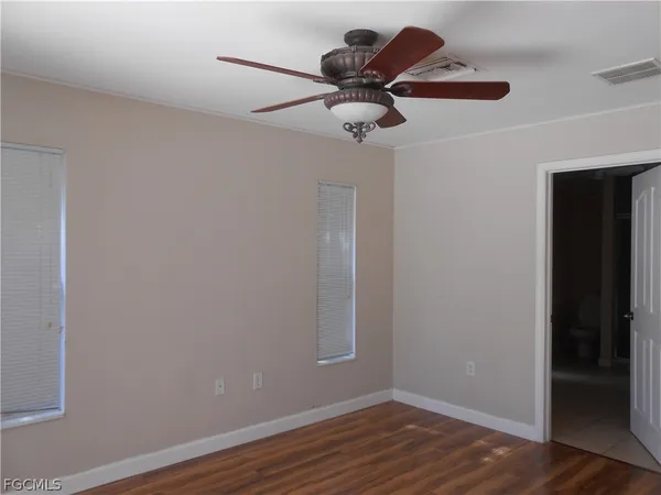 a view of a room with wooden floor and ceiling fan