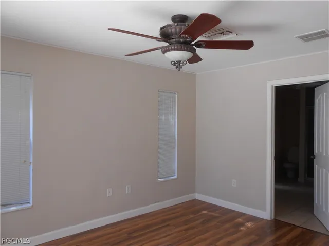 a view of a room with wooden floor and ceiling fan