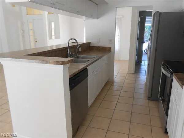 a kitchen with granite countertop a sink and a refrigerator