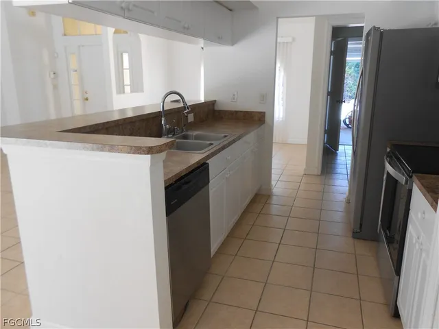 a kitchen with granite countertop a sink and a refrigerator