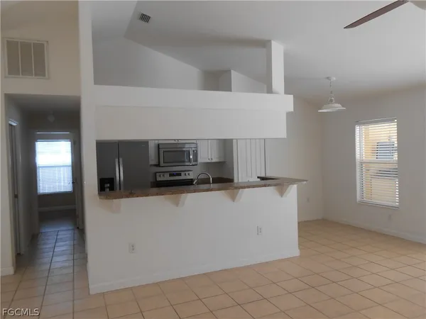 a view of kitchen with microwave cabinets and refrigerator