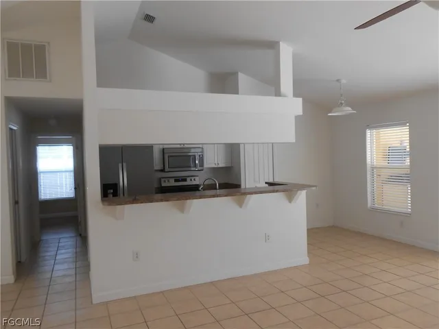 a view of kitchen with microwave cabinets and refrigerator