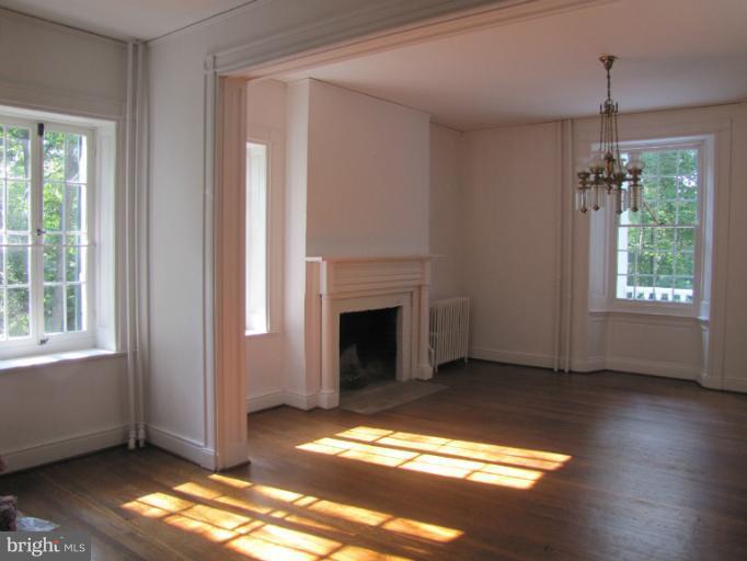 142 Falling Spring Road Shepherdstown, WV 25443 - Photo 15 of 27 a view of a livingroom with wooden floor a fireplace and windows