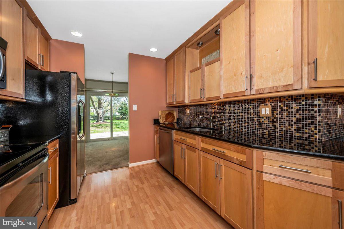 17305 Hoskinson Road Poolesville, MD 20837 - Photo 11 of 81 a kitchen with granite countertop a stove a sink and a microwave