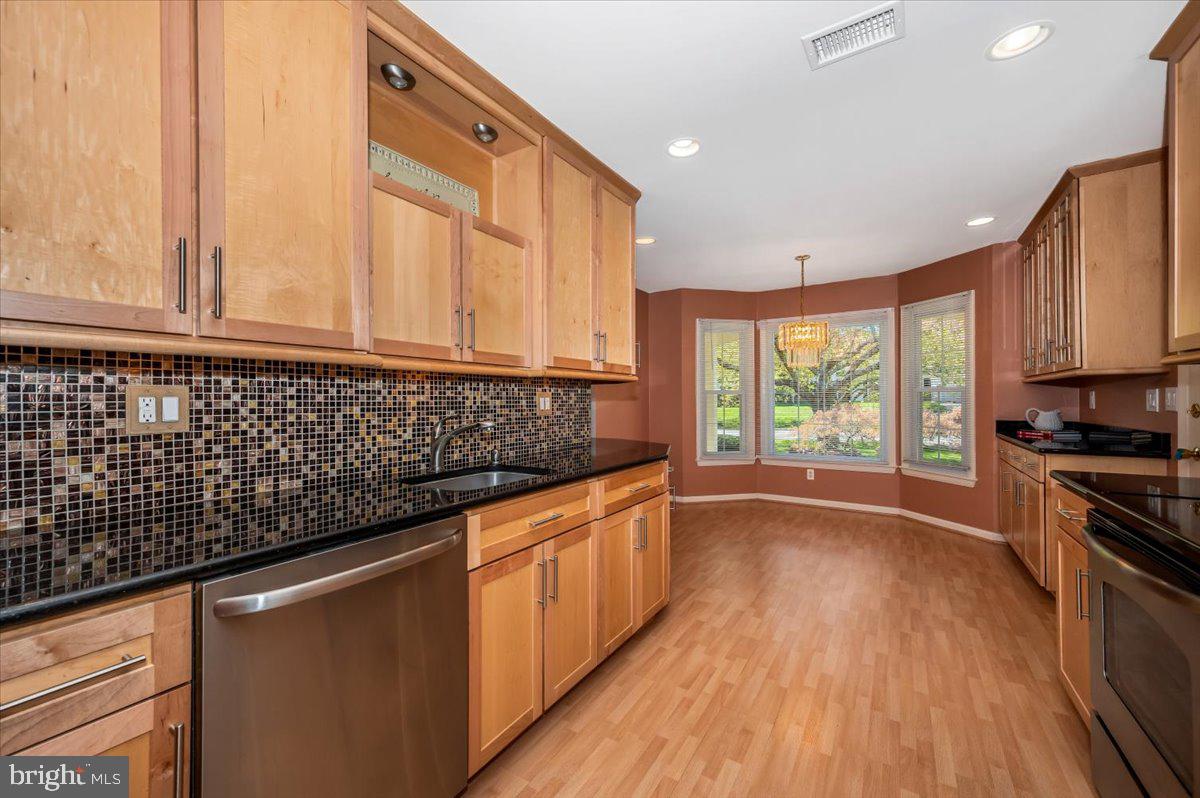 17305 Hoskinson Road Poolesville, MD 20837 - Photo 5 of 81 a kitchen with granite countertop wooden floors a stove and white cabinets