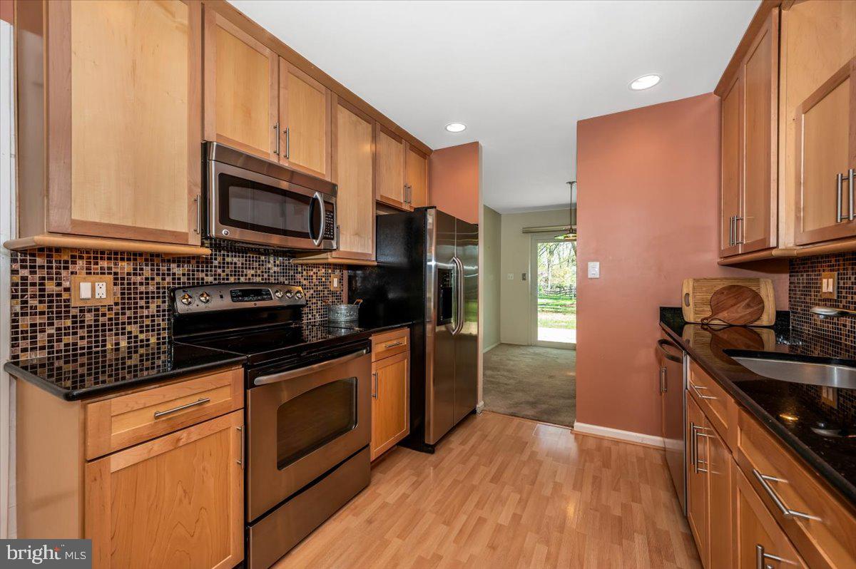 17305 Hoskinson Road Poolesville, MD 20837 - Photo 10 of 81 a kitchen with stainless steel appliances a stove a sink cabinets and a wooden floor