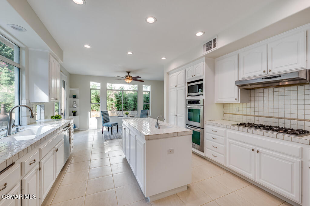 11292 Broadview Drive Moorpark, CA 93021 - Photo 27 of 58 a large white kitchen with stainless steel appliances granite countertop a stove and a sink