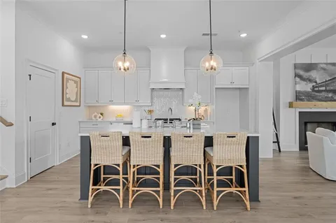 a large kitchen with kitchen island a dining table chairs and wooden floor