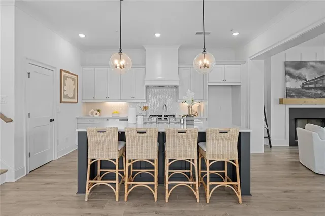 a large kitchen with kitchen island a dining table chairs and wooden floor