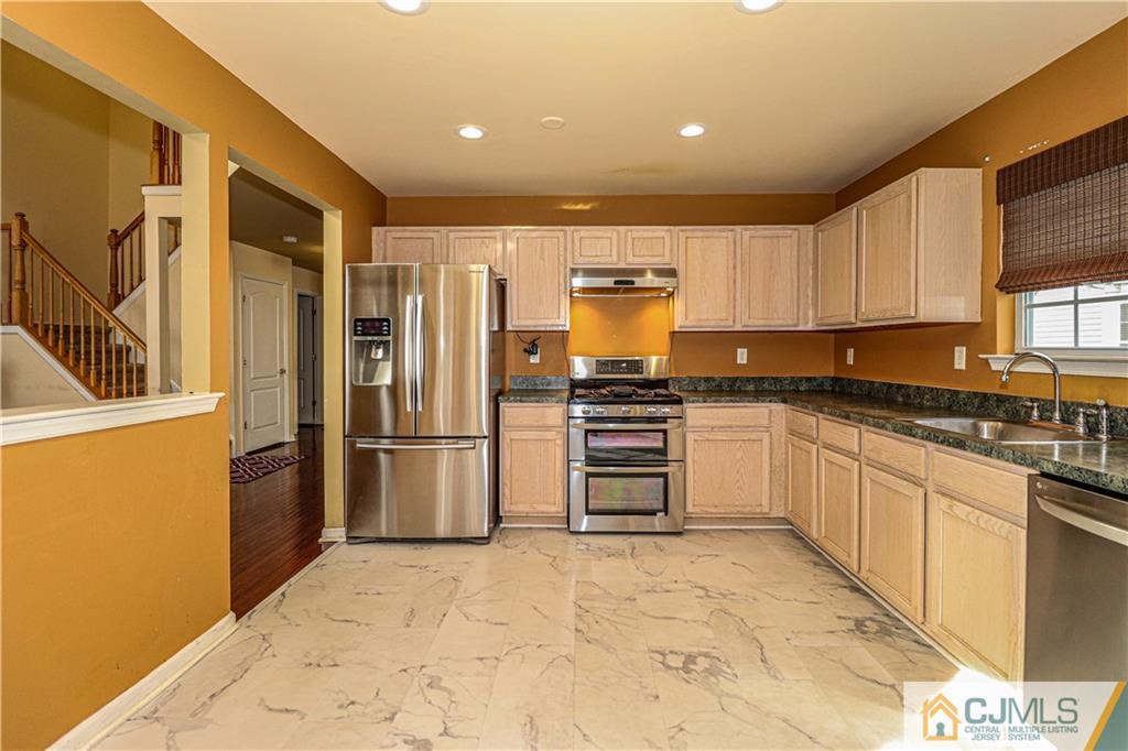 30 Hawthorne Road North Brunswick, NJ 08902 - Photo 13 of 40 a kitchen with stainless steel appliances a refrigerator and a stove top oven