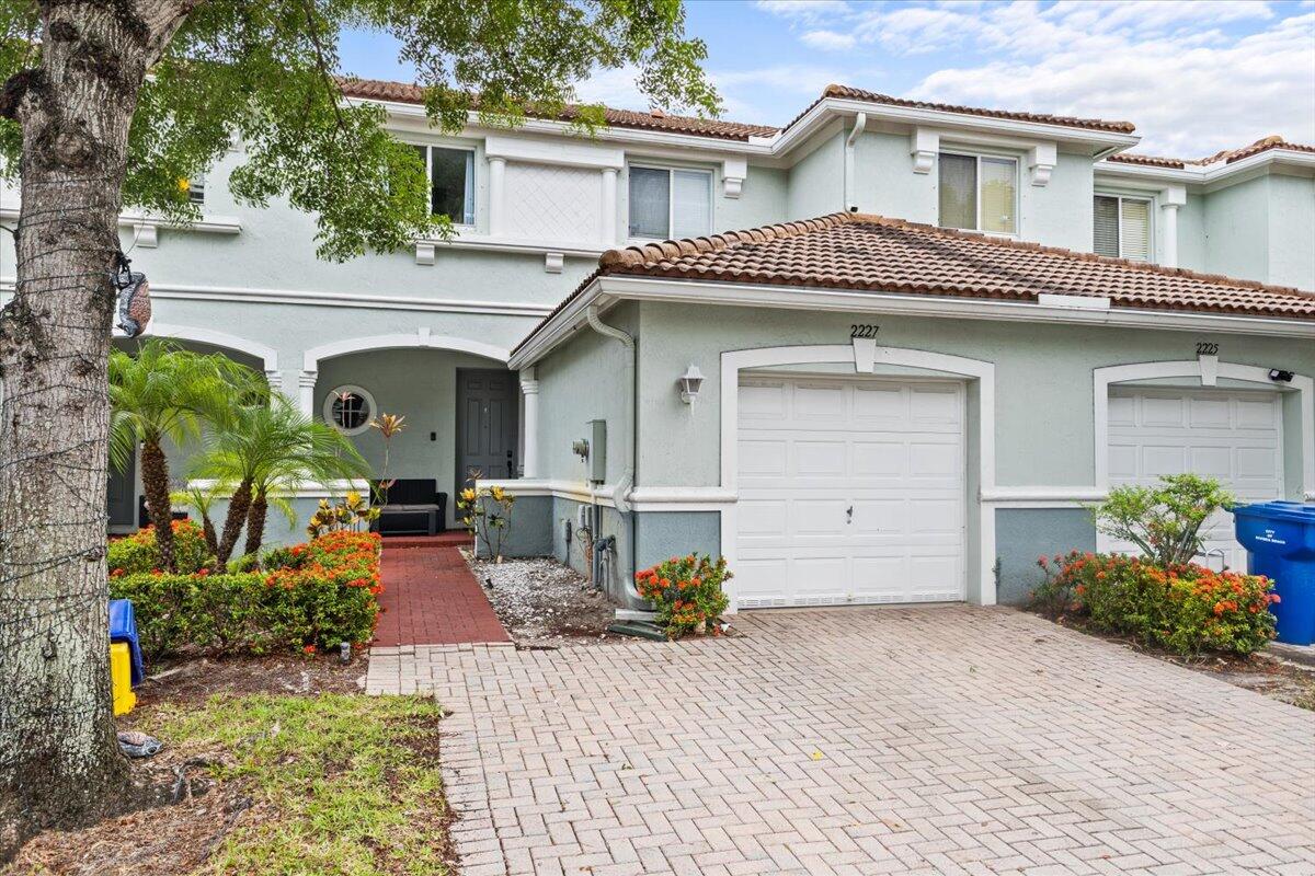 2227 Oakmont Drive Riviera Beach, FL 33404 - Photo 2 of 43 a front view of a house with potted plants