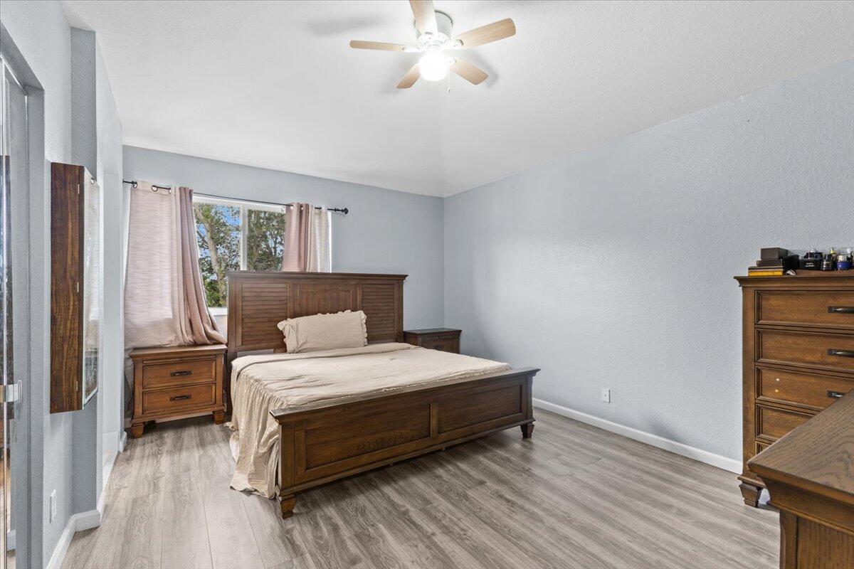 2227 Oakmont Drive Riviera Beach, FL 33404 - Photo 22 of 43 a bedroom with a bed and wooden floor
