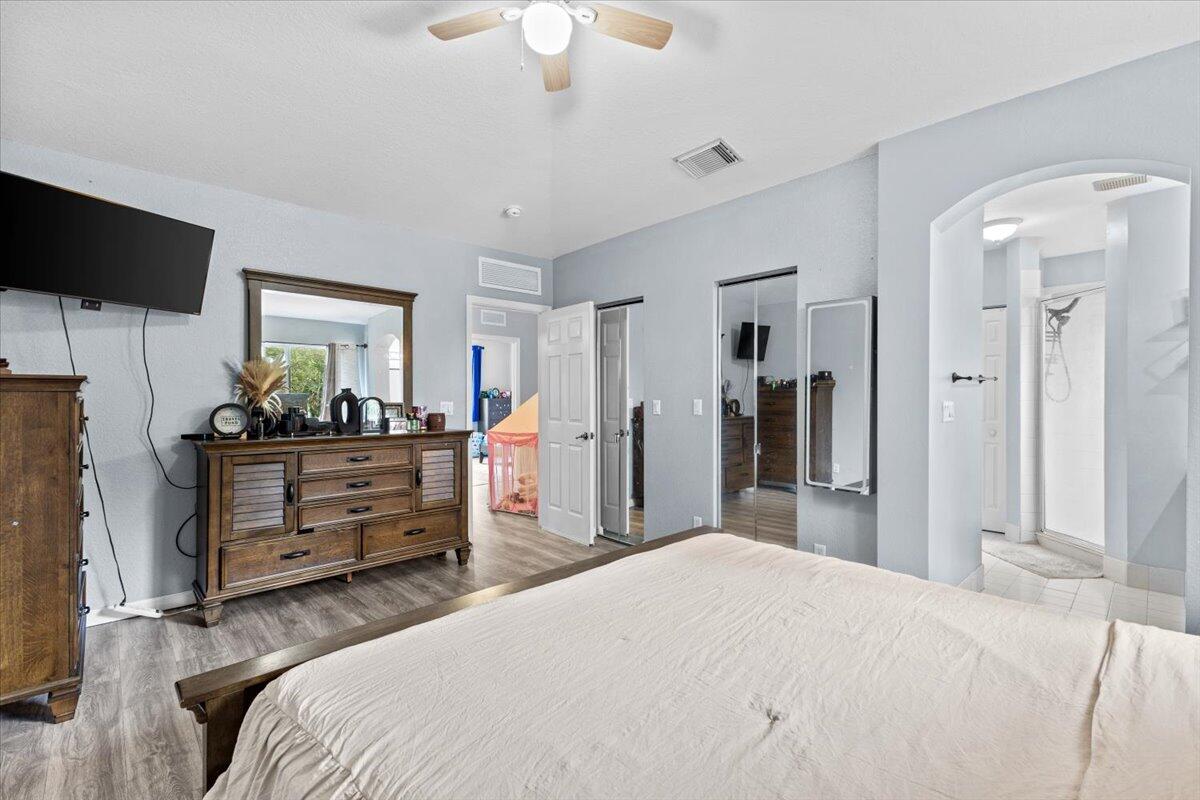 2227 Oakmont Drive Riviera Beach, FL 33404 - Photo 23 of 43 a bedroom with a bed and a flat tv screen on dresser
