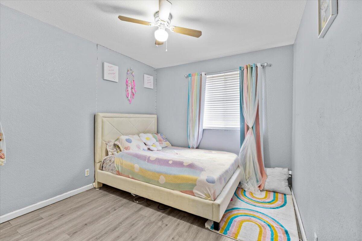 2227 Oakmont Drive Riviera Beach, FL 33404 - Photo 27 of 43 a bedroom with a bed and a chandelier