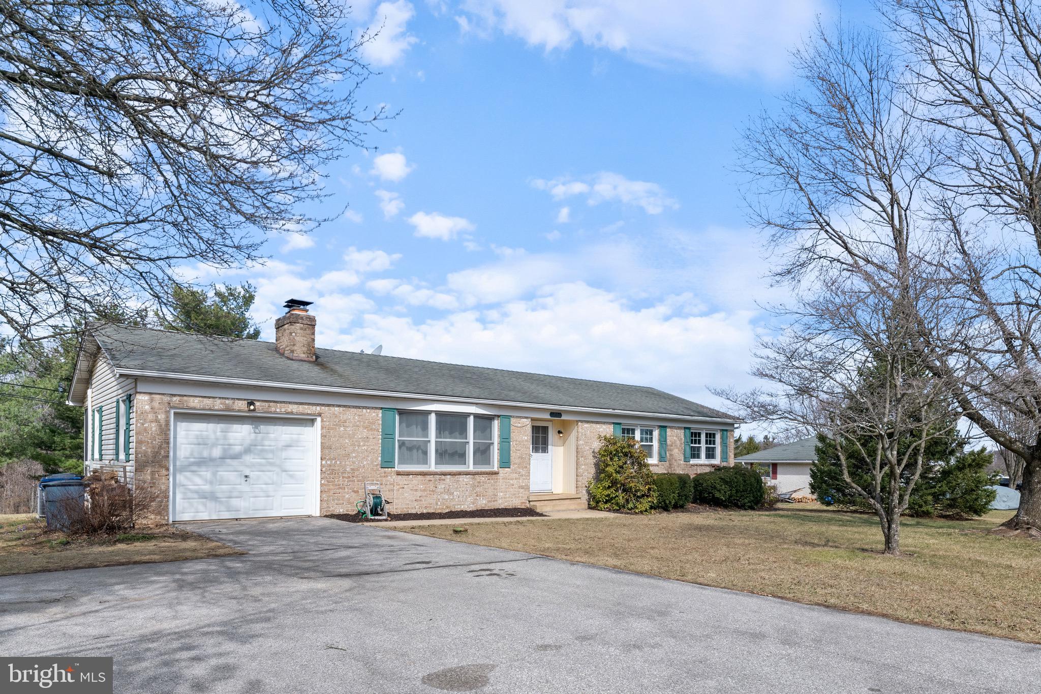 a front view of a house with a garden and trees