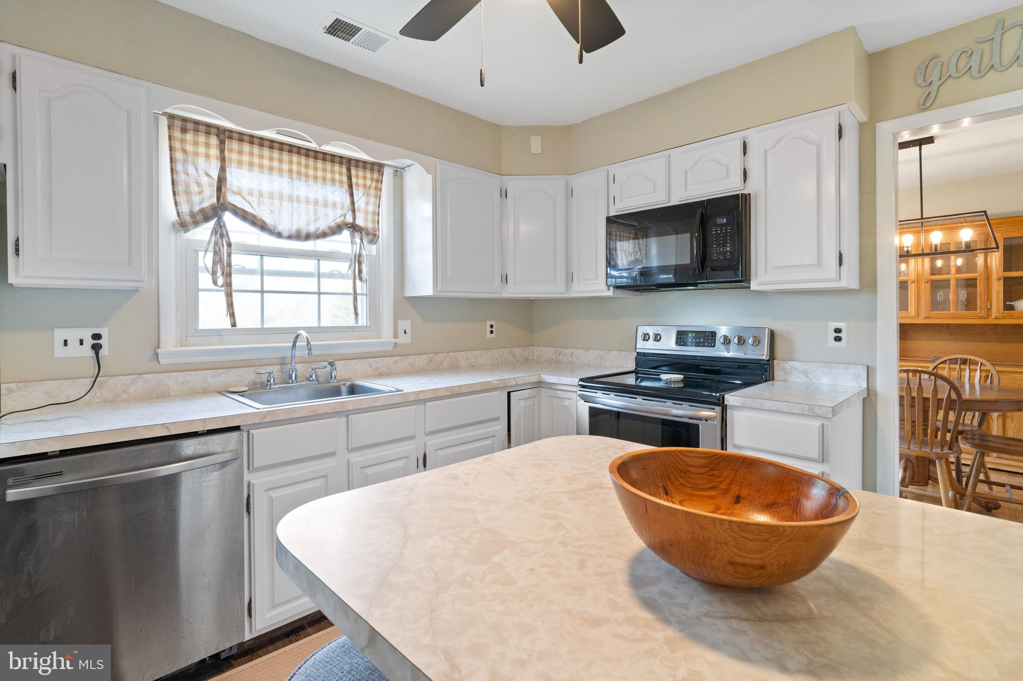 1204 Random Ridge Road Westminster, MD 21157 - Photo 12 of 33 a kitchen with stainless steel appliances a stove a sink a microwave a refrigerator and cabinets