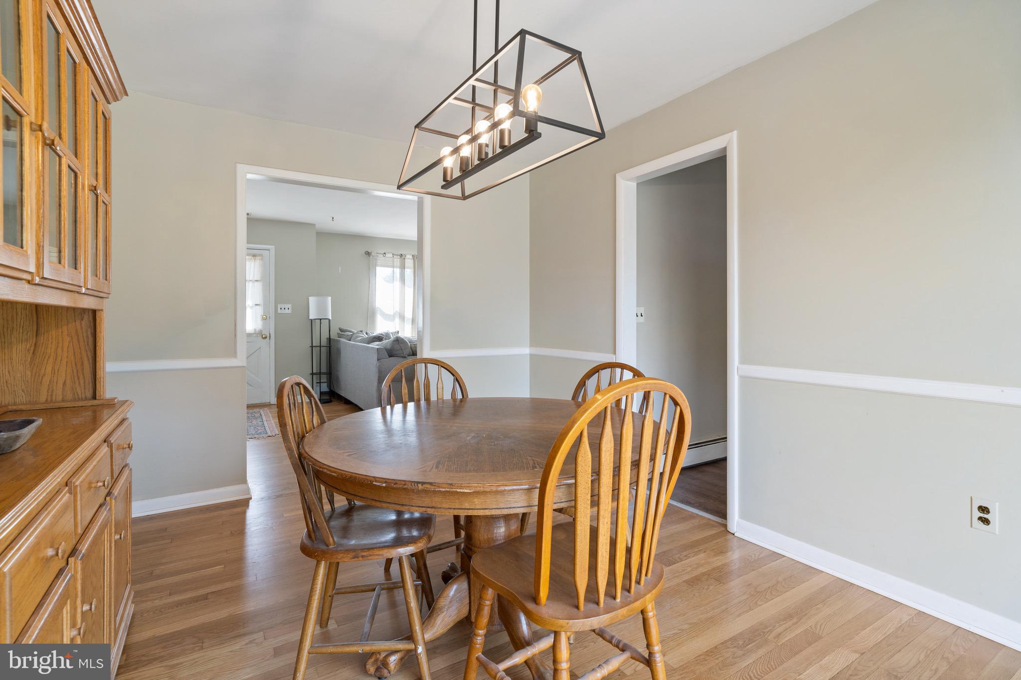 1204 Random Ridge Road Westminster, MD 21157 - Photo 10 of 33 a dining room with furniture a chandelier and wooden floor