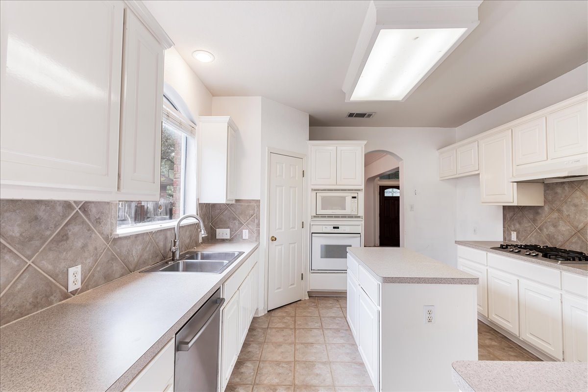 1253 Fall Creek Loop Cedar Park, TX 78613 - Photo 12 of 40 a kitchen with a sink stove and refrigerator