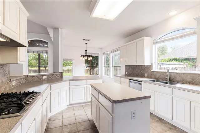 a kitchen with a sink stove top oven and cabinets