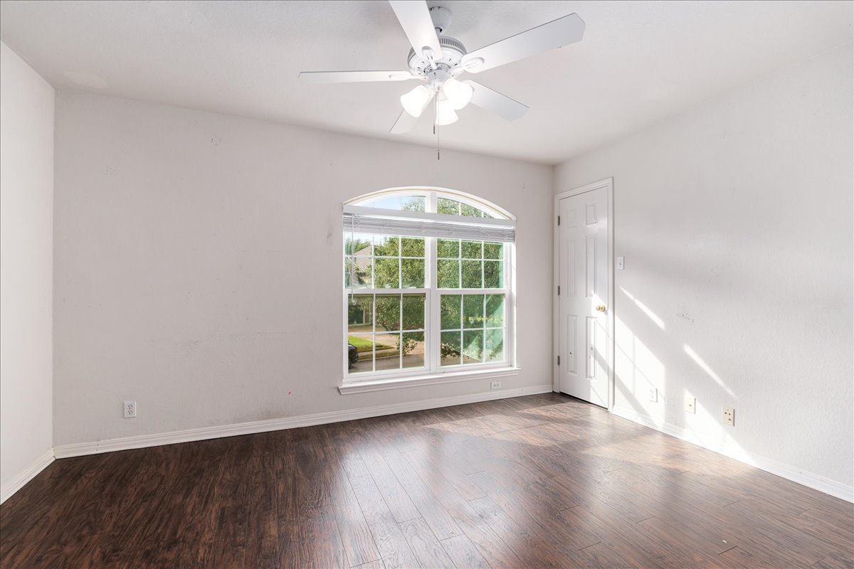 1253 Fall Creek Loop Cedar Park, TX 78613 - Photo 32 of 40 an empty room with wooden floor chandelier fan and windows