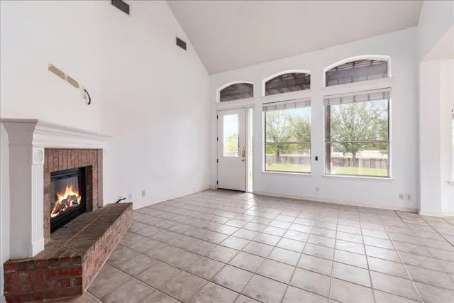 a view of an empty room with window and fire place