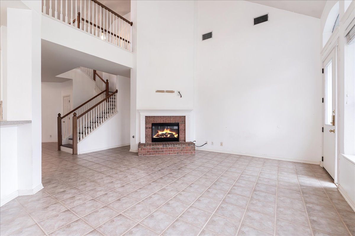 1253 Fall Creek Loop Cedar Park, TX 78613 - Photo 10 of 40 a view of an empty room with stairs and a fireplace