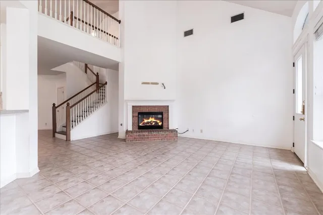 a view of an empty room with stairs and a fireplace