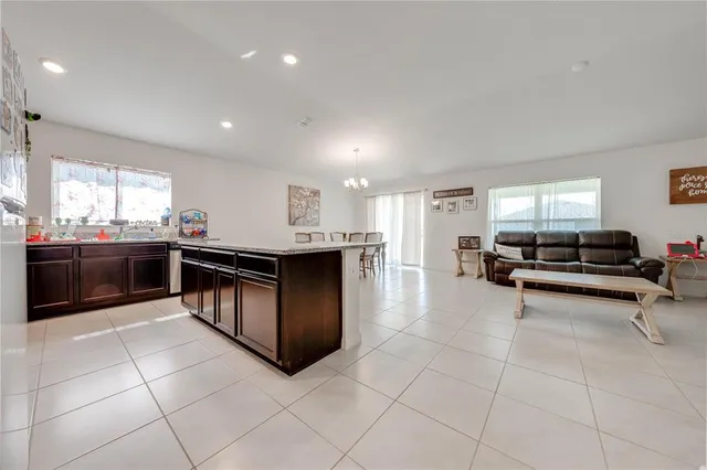 a large kitchen with kitchen island a sink table and chairs