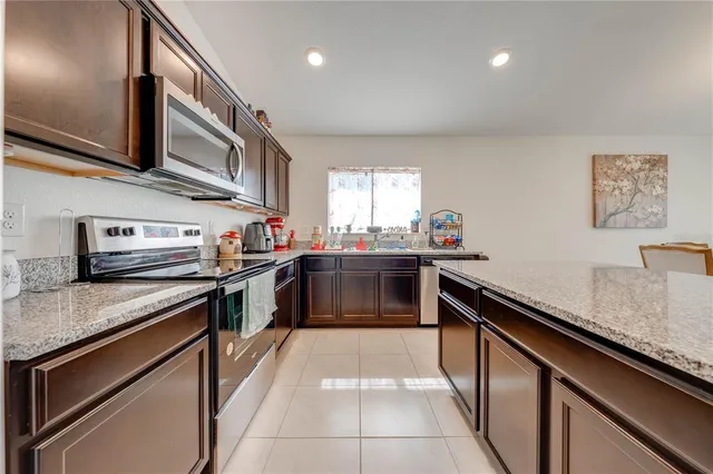 a kitchen with stainless steel appliances a stove microwave and refrigerator