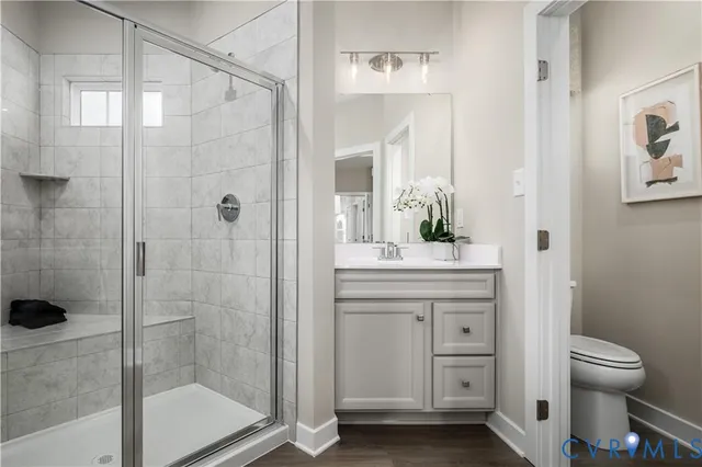a bathroom with a granite countertop sink a toilet and shower