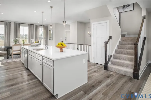 a open kitchen with a sink and wooden floor