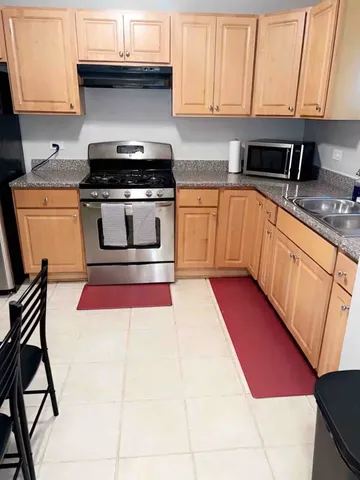 a kitchen with stainless steel appliances granite countertop a stove a sink and a microwave