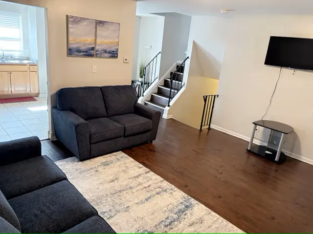 a living room with furniture and a wooden floor