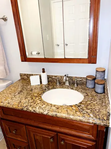 a bathroom with a granite countertop sink and a mirror